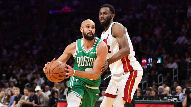 MIAMI, FLORIDA - APRIL 01: Derrick White #9 of the Boston Celtics drives to the basket against Andrew Wiggins #22 of the Miami Heat during the second quarter of the game at Kaseya Center on April 01, 2026 in Miami, Florida.