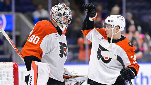ELMONT, NEW YORK - APRIL 03: Dan Vladar #80 and Matvei Michkov #39 of the Philadelphia Flyers celebrate after defeating the New York Islanders 4-1 at UBS Arena on April 03, 2026 in Elmont, New York.