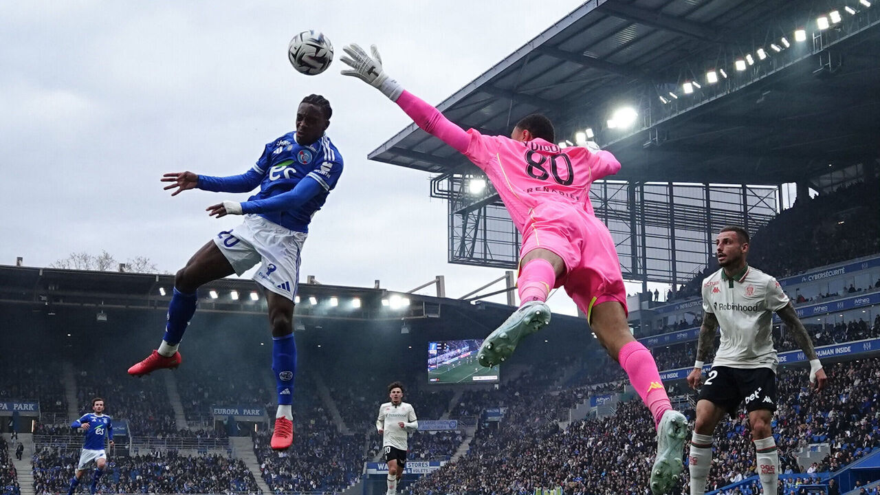 TOPSHOT - Strasbourg's Ivorian-British forward #20 Martial Godo (L) fights for the ball with Nice's Senegalese goalkeeper #80 Yehvann Diouf (C) during the French L1 football match between RC Strasbourg Alsace and OGC Nice at the Stade de la Meinau in Strasbourg, eastern France, on April 4, 2026.
