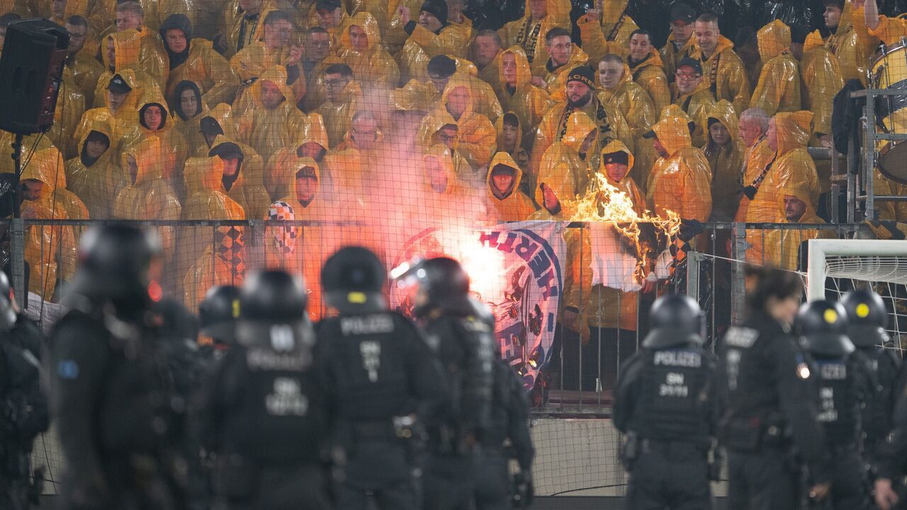 dpatop - 04 April 2026, Saxony, Dresden: Soccer, men, 2nd Bundesliga, Dynamo Dresden - Hertha BSC, matchday 28, at the Rudolf-Harbig-Stadium, police officers stand in front of the K-Block with Dresden fans during a stoppage in play in the stadium. Photo: Sebastian Kahnert/dpa - IMPORTANT NOTE: In accordance with the regulations of the DFL German Football League and the DFB German Football Association, it is prohibited to utilize or have utilized photographs taken in the stadium and/or of the match in the form of sequential images and/or video-like photo series.