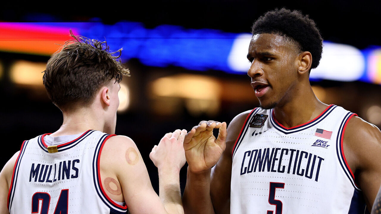 INDIANAPOLIS, INDIANA - APRIL 04: Tarris Reed Jr. #5 of the Connecticut Huskies high fives Braylon Mullins #24 in the second half against the Illinois Fighting Illini in the Final Four of the 2026 NCAA Men's Basketball Tournament at Lucas Oil Stadium on April 04, 2026 in Indianapolis, Indiana.
