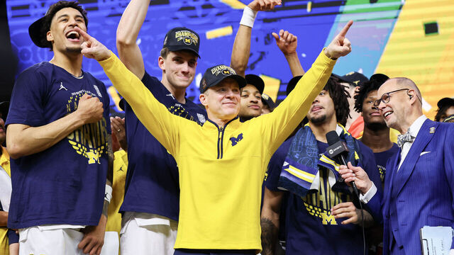 INDIANAPOLIS, INDIANA - APRIL 06: Head Coach Dusty May of the Michigan Wolverines celebrates with his team after defeating the UConn Huskies in the National Championship of the 2026 NCAA Men's Basketball Tournament at Lucas Oil Stadium on April 06, 2026 in Indianapolis, Indiana.