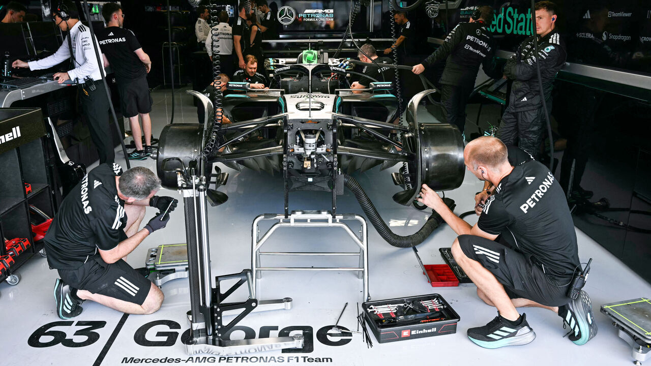 Mercedes technicians work on the car of Mercedes' British driver George Russell in the garage during the practice session for the United States Formula One Grand Prix at the Circuit of the Americas in Austin, Texas, on October 17, 2025.