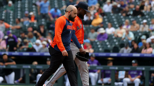 DENVER, CO - APRIL 8: Starting pitcher Cristian Javier #53 of the Houston Astros (R) walks off the field with a member of the training staff before being unable to pitch in the second inning against the Colorado Rockies at Coors Field on April 8, 2026 in Denver, Colorado.