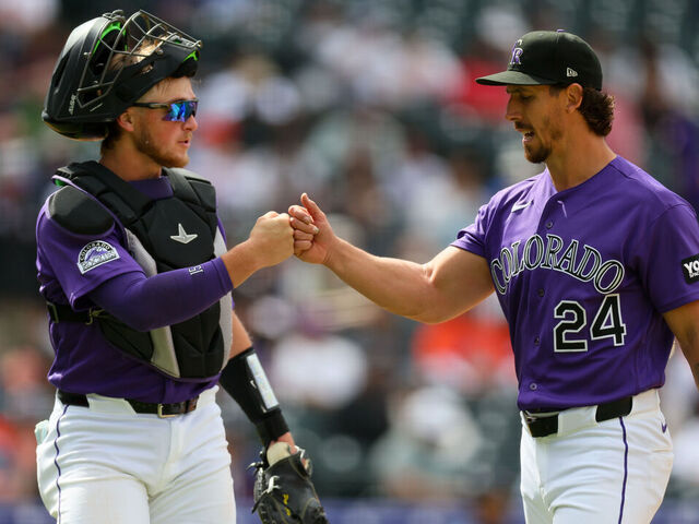 DENVER, CO - APRIL 8: Michael Lorenzen #24 of the Colorado Rockies fist-bumps teammate Hunter Goodman #15 as he walks off the field in the fifth inning against the Houston Astros at Coors Field on April 8, 2026 in Denver, Colorado.