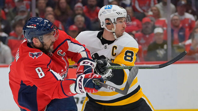 WASHINGTON, DC - DECEMBER 10: Washington Capitals left wing Alex Ovechkin (8), left, gets a shot off as he checked by Pittsburgh Penguins center Sidney Crosby (87)during a game between the Washington Capitals and the Pittsburgh Penguins at Capital One Arena on December 10, 2021 in Washington, DC.