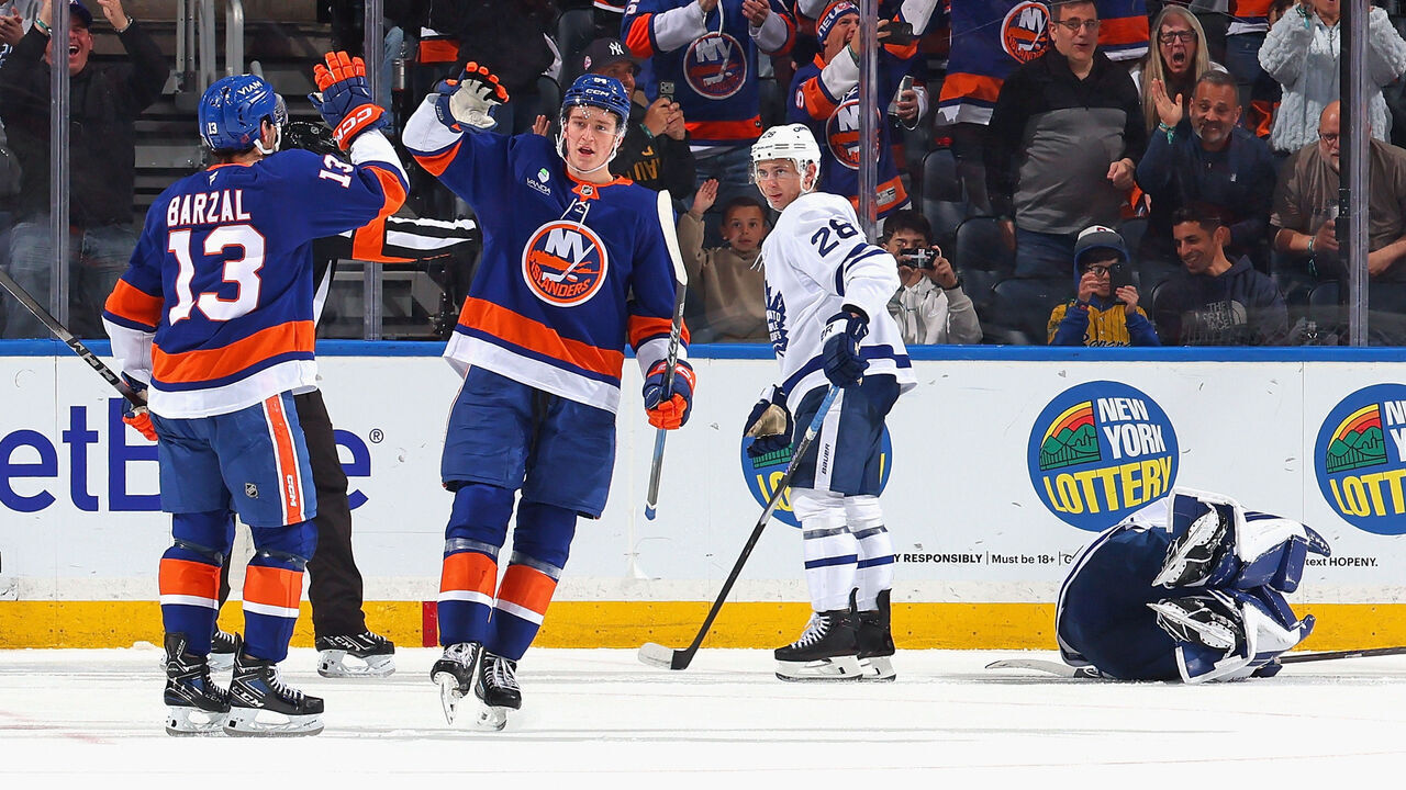 ELMONT, NEW YORK - APRIL 09: Calum Ritchie #64 of the New York Islanders celebrates his third period goal against Artur Akhtyamov #70 of the Toronto Maple Leafs and is joined by Mathew Barzal #13 at UBS Arena on April 09, 2026 in Elmont, New York.