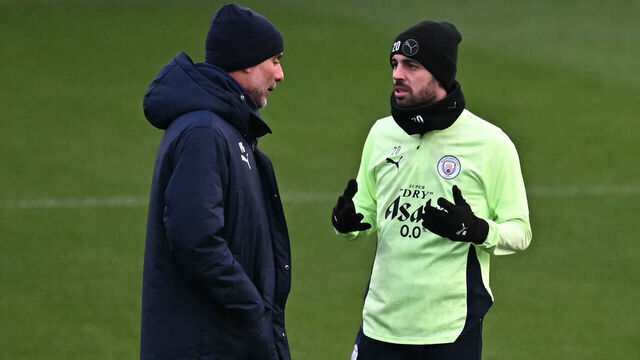 Manchester City's Spanish manager Pep Guardiola (L) speaks with Manchester City's Portuguese midfielder #20 Bernardo Silva (R) during a team training session at Manchester City's training ground in Manchester, north-west England, on November 24, 2025, on the eve of their UEFA Champions League football match against Bayer Leverkusen.