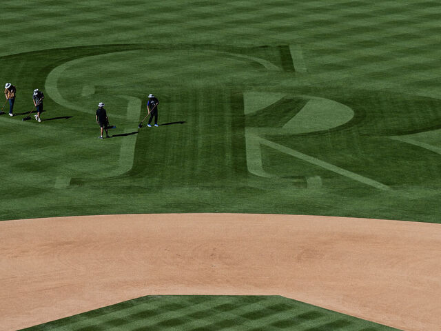 DENVER, CO - APRIL 2: Grounds crews use brooms to brush the Colorado Rockies' logo into the outfield grass on Thursday, April 2, 2026, at Coors Field in Denver, Colo.