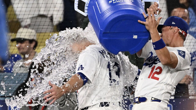 Los Angeles, CA - April 10: Alex Call #12 dumps the water bucket on Max Muncy #13 of the Los Angeles Dodgers after he hit a walk off home run and his third home run of the night against the Texas Rangers in the ninth inning of a baseball game at Dodger Stadium in Los Angeles on Friday, April 10, 2026. Dodgers won 8-7.