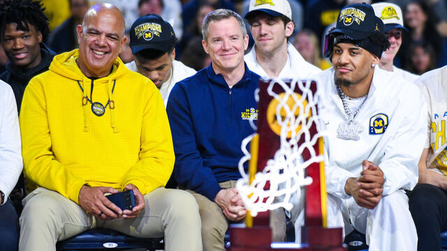 ANN ARBOR, MICHIGAN - APRIL 11: (L-R) University of Michigan Athletic Director Warde Manuel, Head Basketball Coach Dusty May, and Yaxel Lendeborg #23 of the Michigan Wolverines look on during the Michigan Men's Basketball National Championship celebration at Crisler Arena on April 11, 2026 in Ann Arbor, Michigan.
