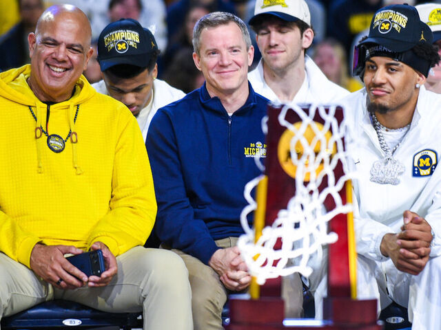 ANN ARBOR, MICHIGAN - APRIL 11: (L-R) University of Michigan Athletic Director Warde Manuel, Head Basketball Coach Dusty May, and Yaxel Lendeborg #23 of the Michigan Wolverines look on during the Michigan Men's Basketball National Championship celebration at Crisler Arena on April 11, 2026 in Ann Arbor, Michigan.