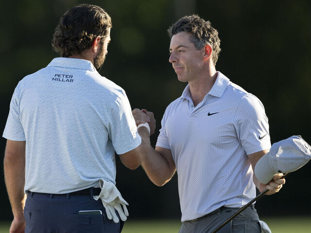 Masters champion Rory McIlroy of Northern Ireland shakes hands with Cameron Young of the United States on the No. 18 hole during the second round of the Masters at Augusta National Golf Club, Friday, April 10, 2026.