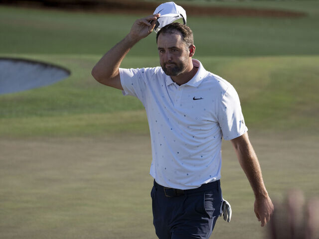 Masters champion Scottie Scheffler of the United States tips his hat to the patrons on the No. 18 green during the final round of the Masters at Augusta National Golf Club, Sunday, April 12, 2026.