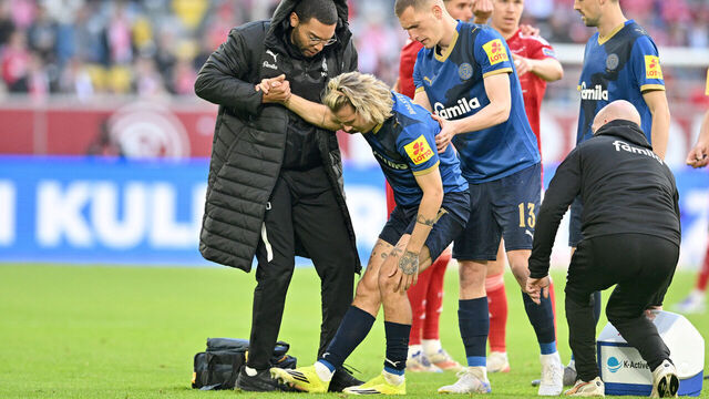 10 April 2026, North Rhine-Westphalia, Duesseldorf: Soccer, Men: Bundesliga 2, Fortuna Düsseldorf - Holstein Kiel, Matchday 29, Merkur Spiel-Arena. John Tolkin (Holstein Kiel) is injured, (r) Ivan Nekic (Holstein Kiel) helps him up. Photo: Anke Waelischmiller/dpa - IMPORTANT NOTE: In accordance with the regulations of the DFL German Football League and the DFB German Football Association, it is prohibited to utilize or have utilized photographs taken in the stadium and/or of the match in the form of sequential images and/or video-like photo series.