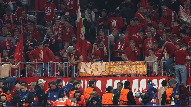 A photographer is treated after fans climbed over the fence after the UEFA Champions League quarter-final second leg football match between FC Bayern Munich and Real Madrid in Munich, southern Germany, on April 15, 2026. Bayern Munich supporters have apologised after several photographers were injured when fans stormed over barriers at the end of Wednesday's home Champions League quarter-final against Real Madrid.