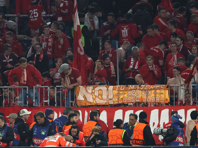 A photographer is treated after fans climbed over the fence after the UEFA Champions League quarter-final second leg football match between FC Bayern Munich and Real Madrid in Munich, southern Germany, on April 15, 2026. Bayern Munich supporters have apologised after several photographers were injured when fans stormed over barriers at the end of Wednesday's home Champions League quarter-final against Real Madrid.