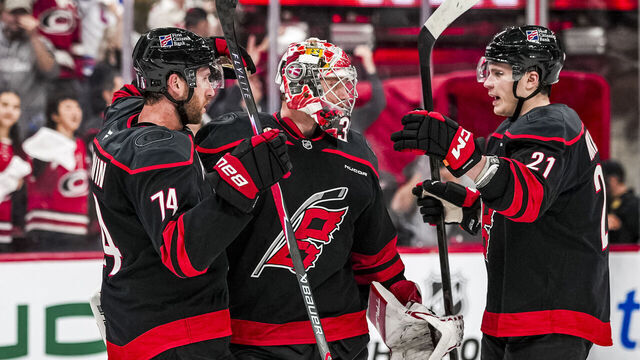 RALEIGH, NORTH CAROLINA - APRIL 18: Jaccob Slavin #74, Frederik Andersen #31, and Alexander Nikishin #21 of the Carolina Hurricanes celebrate on the ice after winning Game One of the First Round of the 2026 Stanley Cup Playoffs against the Ottawa Senators at Lenovo Center on April 18, 2026 in Raleigh, North Carolina.