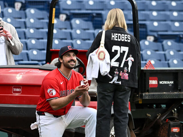 CLEVELAND, OHIO - APRIL 19: Austin Hedges #27 of the Cleveland Guardians proposes to his girlfriend Lexi Dickinson after the team's 8-4 win over the Baltimore Orioles at Progressive Field on April 19, 2026 in Cleveland, Ohio.