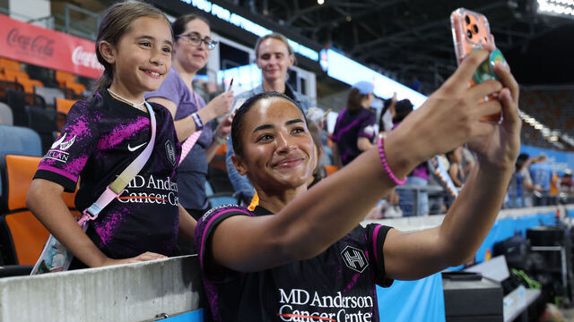 HOUSTON, TEXAS - APRIL 03: Kiki Van Zanten #12 of Houston Dash takes a selfie with the fans after the NWSL match between Houston Dash and Racing Louisville FC at Shell Energy Stadium on April 03, 2026 in Houston, Texas.