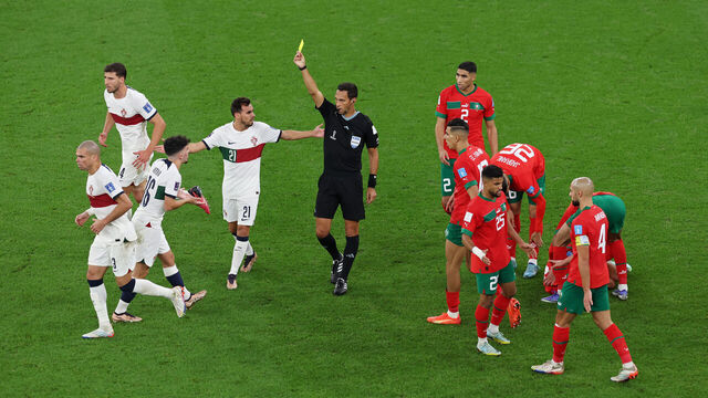 DOHA, QATAR - DECEMBER 10: Vitinha of Portugal is shown a yellow card by referee Facundo Tello during the FIFA World Cup Qatar 2022 quarter final match between Morocco and Portugal at Al Thumama Stadium on December 10, 2022 in Doha, Qatar.