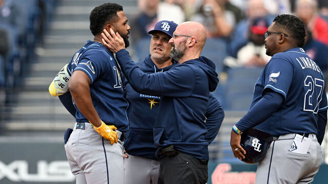 CLEVELAND, OHIO - APRIL 28: Junior Caminero #13 of the Tampa Bay Rays is checked by a trainer after being injured during the first inning against the Cleveland Guardians at Progressive Field on April 28, 2026 in Cleveland, Ohio.