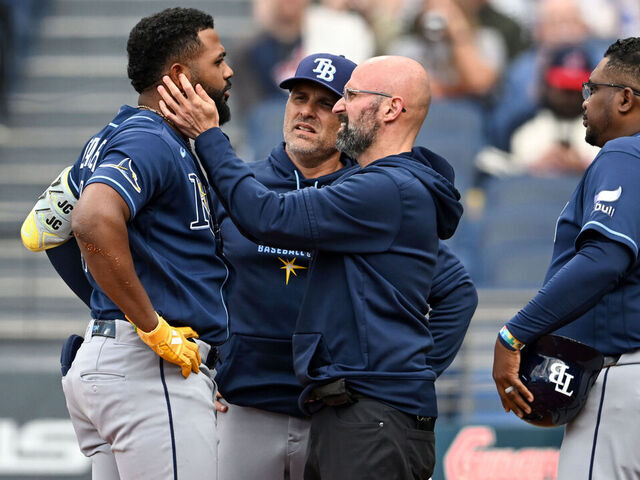 CLEVELAND, OHIO - APRIL 28: Junior Caminero #13 of the Tampa Bay Rays is checked by a trainer after being injured during the first inning against the Cleveland Guardians at Progressive Field on April 28, 2026 in Cleveland, Ohio.