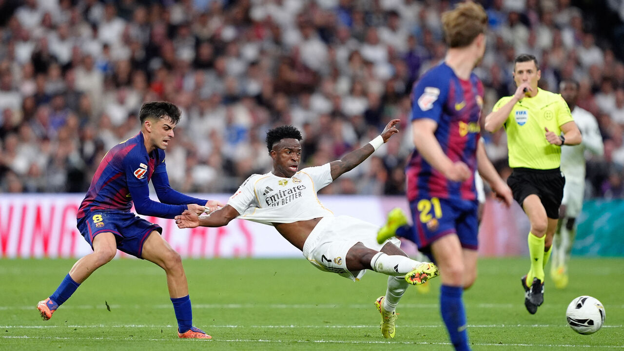 Vinícius Júnior of Real Madrid CF and Pedri of FC Barcelona are seen in action during the LaLiga EA Sports match between Real Madrid CF and FC Barcelona at the Santiago Bernabéu on November 26, 2025 in Madrid, Spain.