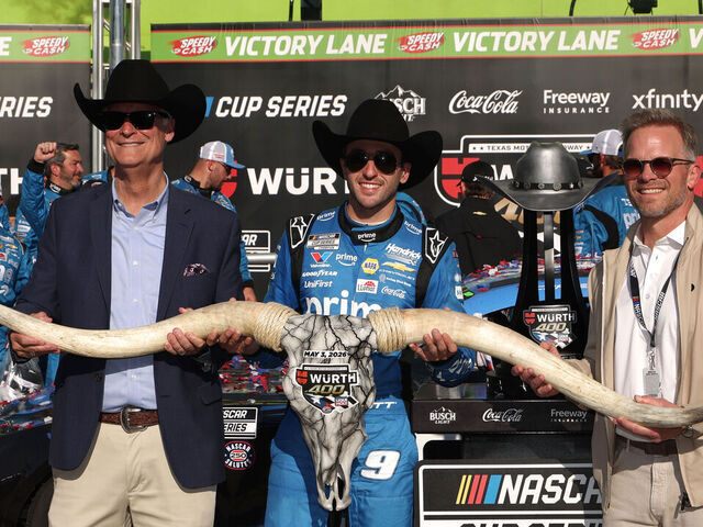 FORT WORTH, TEXAS - MAY 03: Chase Elliott, driver of the #9 Amazon Prime Chevrolet, poses for a photo with Speedway Motorsports Director Marcus Smith and General Manager Mark Faber after winning the NASCAR Cup Series Würth 400 presented by LIQUI MOLY at Texas Motor Speedway on May 03, 2026 in Fort Worth, Texas.