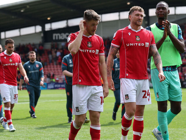WREXHAM, WALES - MAY 02: George Thomason (l) Dan Scarr (c) and Arthur Okonkwo (r) of Wrexham show their disappointment after Wrexham failed to make the Play-Offs following the Sky Bet Championship match between Wrexham AFC and Middlesbrough at Racecourse Ground on May 02, 2026 in Wrexham, Wales.