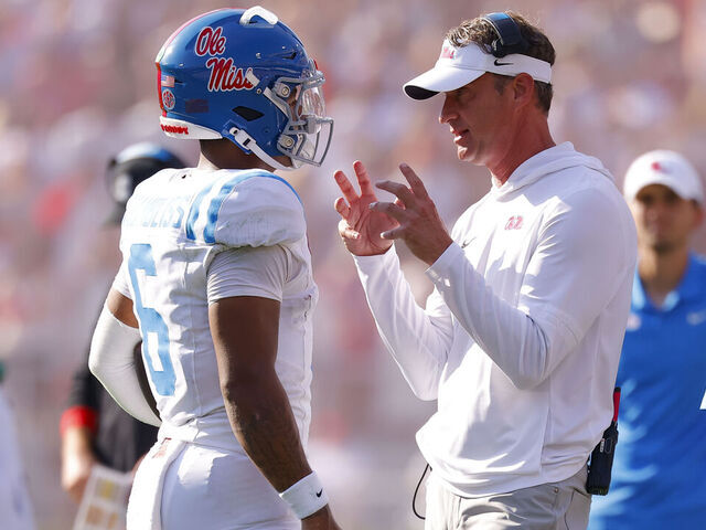 ATHENS, GEORGIA - OCTOBER 18: Head coach Lane Kiffin of the Mississippi Rebels speaks with Trinidad Chambliss #6 during the second quarter against the Georgia Bulldogs at Sanford Stadium on October 18, 2025 in Athens, Georgia.