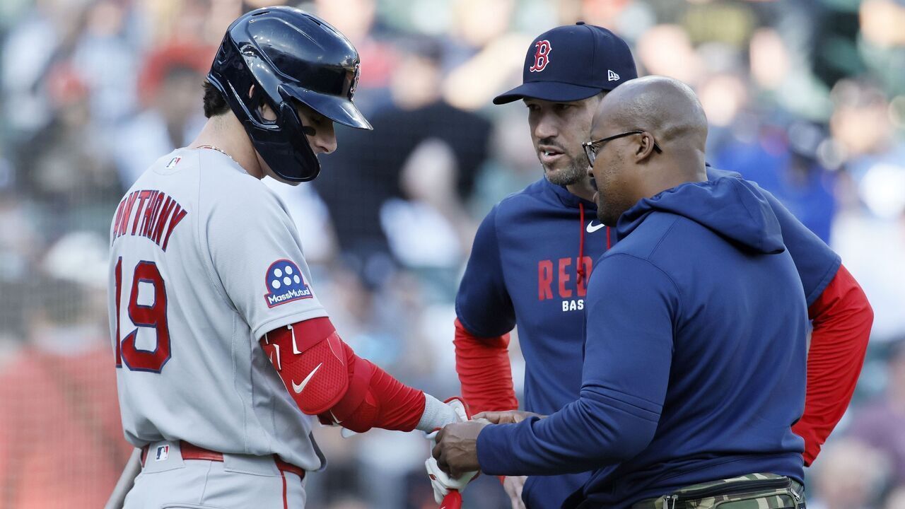 DETROIT, MICHIGAN - MAY 4: Roman Anthony #19 of the Boston Red Sox has his hand examined by trainer Brandon Henry (R) as interim manager Chad Tracy #17 (C) looks on during the first inning of a game against the Detroit Tigers at Comerica Park on May 4, 2026 in Detroit, Michigan.