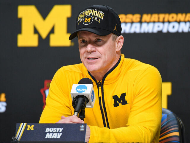 INDIANAPOLIS, INDIANA - APRIL 06: Head Basketball Coach Dusty May of the Michigan Wolverines speaks to media during the post game press conference after winning the 2026 NCAA Men's Basketball Tournament national championship game against the UConn Huskies at Lucas Oil Stadium on April 06, 2026 in Indianapolis, Indiana. The Michigan Wolverines won the game 69-63.