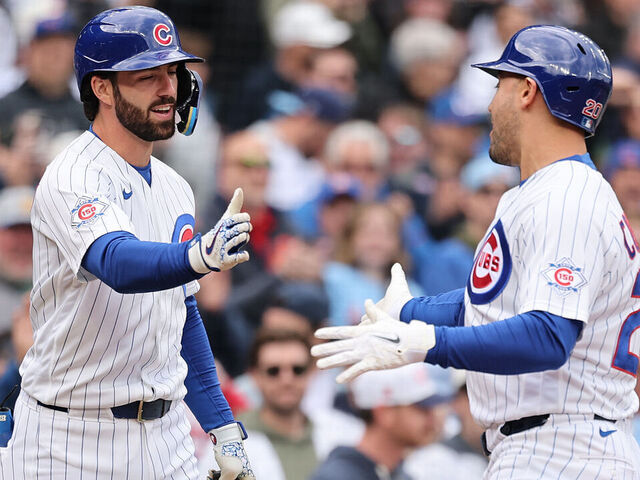 CHICAGO, ILLINOIS - MAY 07: Michael Conforto #20 of the Chicago Cubs high fives Dansby Swanson #7 after hitting a home run against the Cincinnati Reds during the second inning at Wrigley Field on May 07, 2026 in Chicago, Illinois.