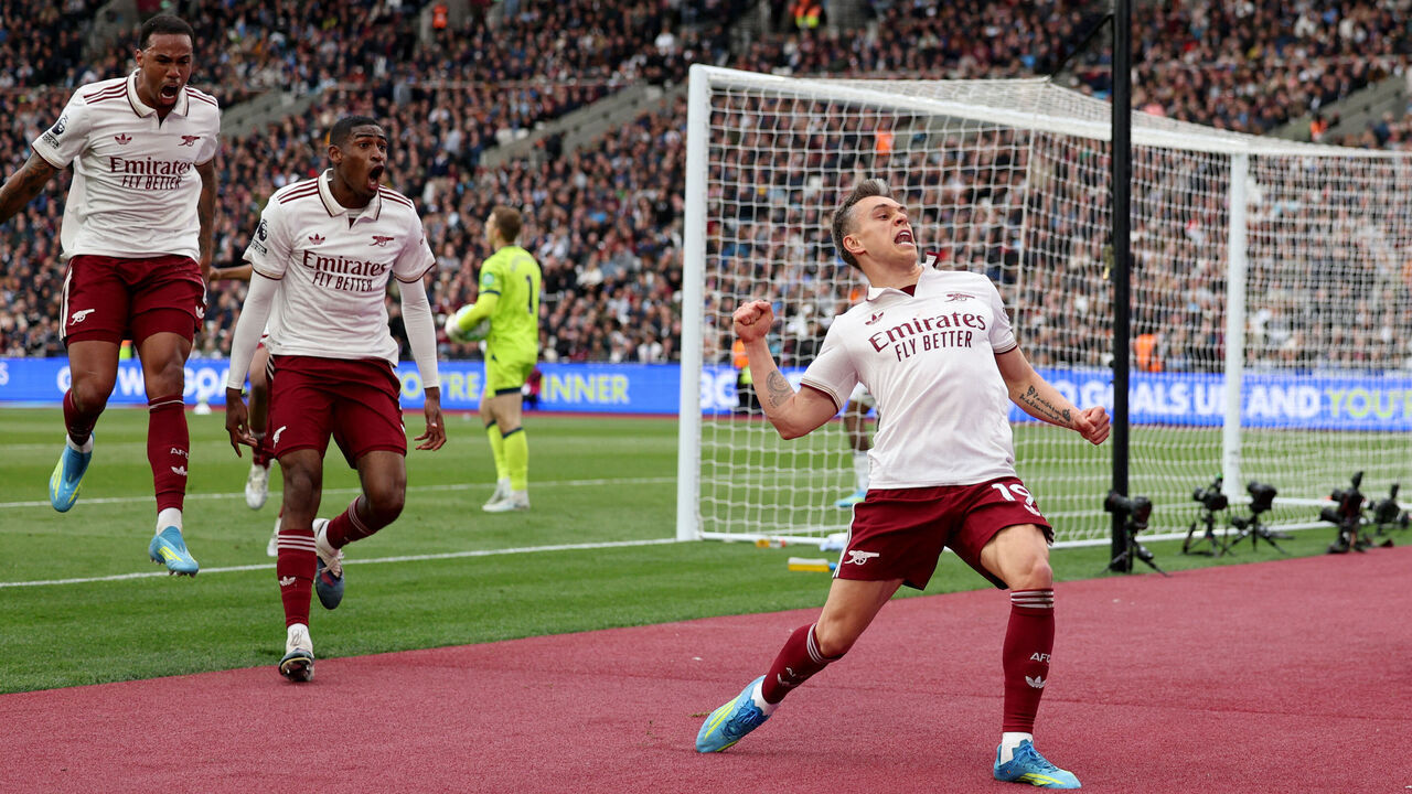 Arsenal's Belgian midfielder #19 Leandro Trossard (R) celebrates scoring the team's first goal during the English Premier League football match between West Ham United and Arsenal at the London Stadium, in east London on May 10, 2026. / RESTRICTED TO EDITORIAL USE. No use with unauthorized audio, video, data, fixture lists, club/league logos or 'live' services. Online in-match use limited to 120 images. An additional 40 images may be used in extra time. No video emulation. Social media in-match use limited to 120 images. An additional 40 images may be used in extra time. No use in betting publications, games or single club/league/player publications. /