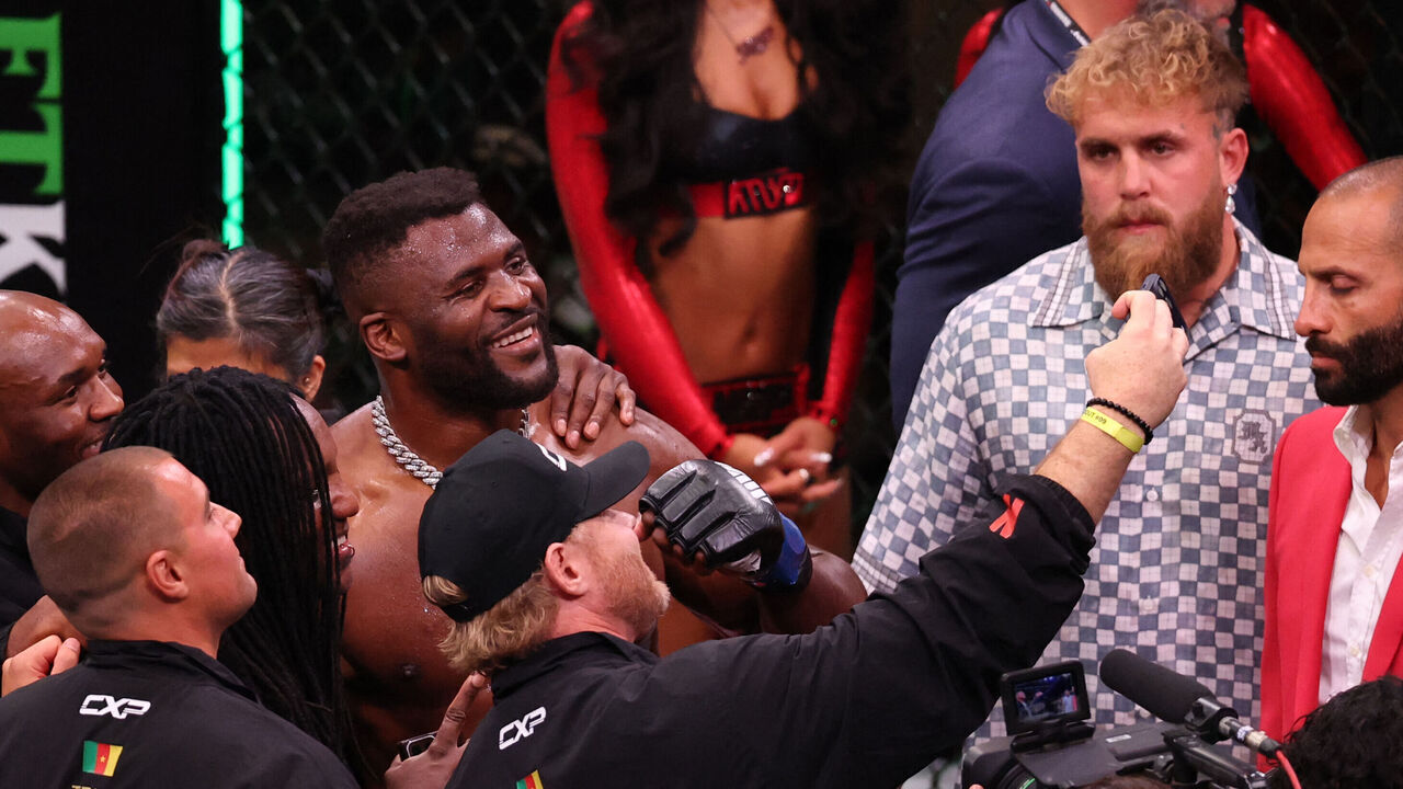 US boxer and influencer Jake Paul (R) looks on as Cameroonian-French mixed martial arts fighter Francis Ngannou (L) takes a selfie with his team after knocking out Brazilian mixed martial arts fighter Philipe Lins during their heavyweight bout at MVP MMA 1 at the Intuit Dome in Inglewood, California, on May 16, 2026.