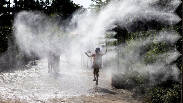 PARIS, FRANCE - MAY 23: A young spectator runs through the cooling sprays on a hot afternoon during Yannick Noah Day at the 2026 French Open Tennis Tournament at Roland Garros on May 23rd, 2026, in Paris, France.
