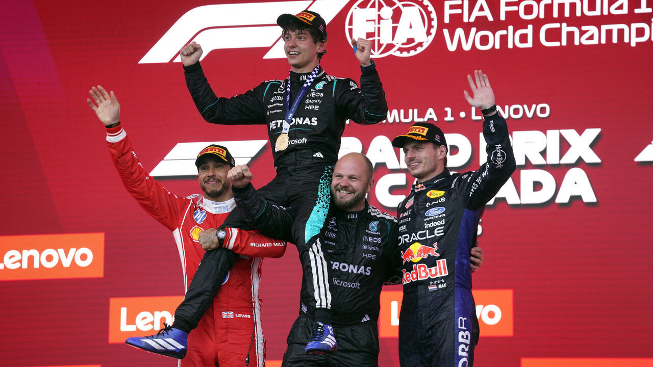TOPSHOT - Race winner Mercedes' Italian driver Kimi Antonelli is lifted by second place Ferrari's British driver Lewis Hamilton (L) and Mercedes' Senior Race Team Composite Technician Dean Hale as third place Red Bull Racing's Dutch driver Max Verstappen join the celebration on the podium at the conclusion of the 2026 Formula 1 Grand Prix du Canada at Circuit Gilles-Villeneuve in Montreal, Canada, on May 24, 2026.