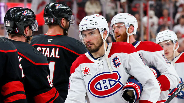 RALEIGH, NORTH CAROLINA - MAY 29: Nick Suzuki #14 of the Montréal Canadiens shakes the hand of Eric Robinson #50 of the Carolina Hurricanes following a 6-1 Carolina Hurricanes victory in Game Five of the Eastern Conference Final of the 2026 Stanley Cup Playoffs at Lenovo Center on May 29, 2026 in Raleigh, North Carolina.