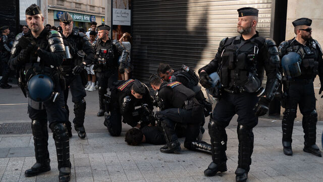 French Republican Security Corps (CRS - Compagnies Republicaines de Securite) police officers detain a Paris Saint-Germain (PSG) supporter during celebrations following their team's win in the UEFA Champions League final against Arsenal FC, played in Budapest, on the Champs-Elysees Avenue in Paris on May 30, 2026.