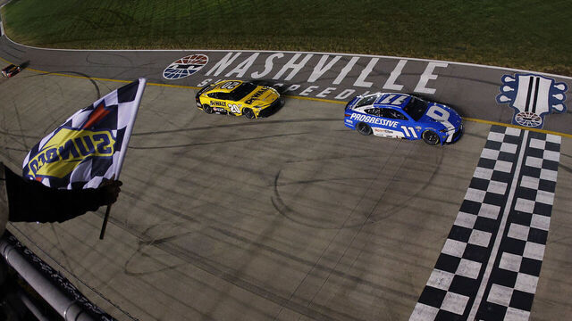 LEBANON, TENNESSEE - MAY 31: Denny Hamlin, driver of the #11 Progressive Insurance Toyota, takes the checkered flag ahead of Christopher Bell, driver of the #20 DeWalt Toyota, to win the NASCAR Cup Series Cracker Barrel 400 at Nashville Superspeedway on May 31, 2026 in Lebanon, Tennessee.