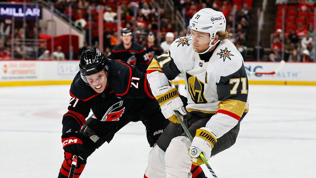 RALEIGH, NORTH CAROLINA - OCTOBER 28: William Karlsson #71 of the Vegas Golden Knights skates with the puck against Alexander Nikishin #21 of the Carolina Hurricanes during the third period of the game at the Lenovo Center on October 28, 2025 in Raleigh, North Carolina.