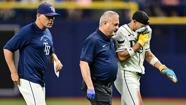 ST PETERSBURG, FLORIDA - JUNE 01: Chandler Simpson #14 of the Tampa Bay Rays is helped off the field by athletic trainer Mike Sandoval and manager Kevin Cash #16 during the fourth inning against the Detroit Tigers at Tropicana Field on June 01, 2026 in St Petersburg, Florida.