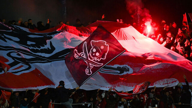 Annecy's supporters light red flares during the French Cup semi-final football match between FC Annecy and Toulouse FC at the Parc Des Sports Stadium in Annecy, south-eastern France on April 6, 2023.
