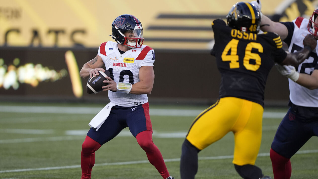 HAMILTON, CANADA - JUNE 4: Davis Alexander #10 of the Montreal Alouettes looks to pass under pressure from Philip Ossai #46 of the Hamilton Tiger-Cats during the first half at Hamilton Stadium on June 4, 2026 in Hamilton, Canada.