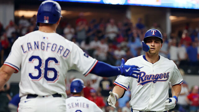 ARLINGTON, TEXAS - AUGUST 09: Wyatt Langford #36 of the Texas Rangers greets Corey Seager #5 of the Texas Rangers after Seager's home run against the Philadelphia Phillies in the eighth inning at Globe Life Field on August 09, 2025 in Arlington, Texas.