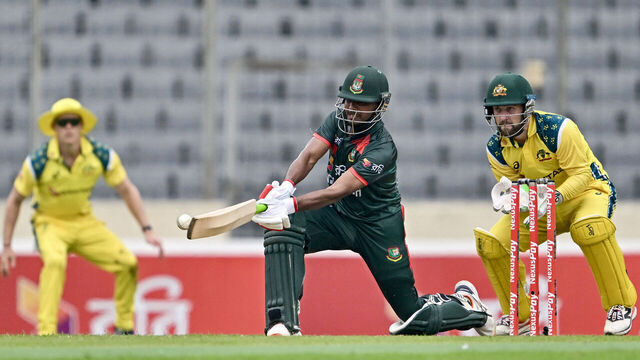 Bangladesh's Mosaddek Hossain (C) plays a shot as Australia's wicketkeeper and captain Josh Inglis (R) watches during the first one-day international (ODI) cricket match between Bangladesh and Australia at the Sher-e-Bangla National Cricket Stadium in Dhaka on June 9, 2026.