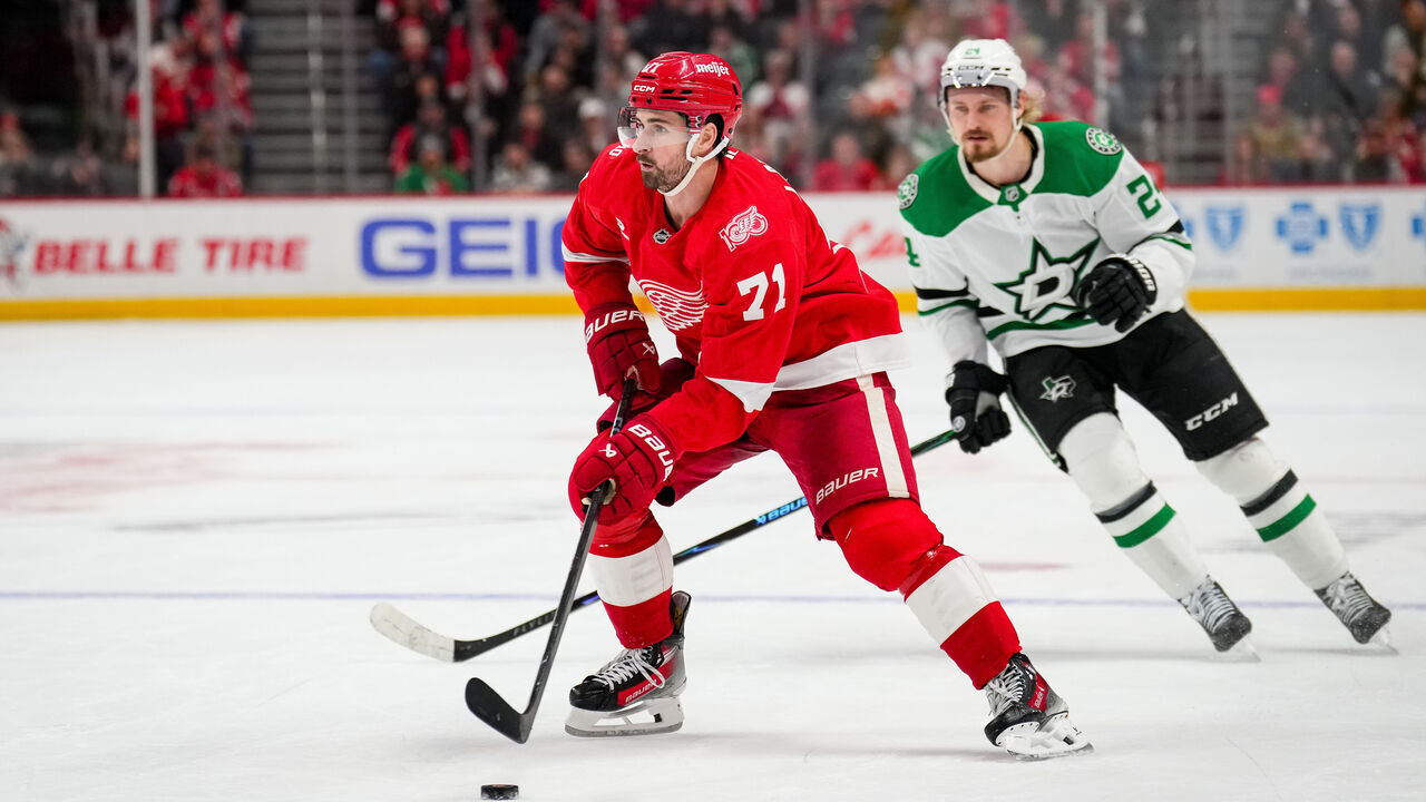 DETROIT, MICHIGAN - DECEMBER 23: Dylan Larkin #71 of the Detroit Red Wings skates with the puck against Roope Hintz #24 of the Dallas Stars at Little Caesars Arena on December 23, 2025 in Detroit, Michigan.
