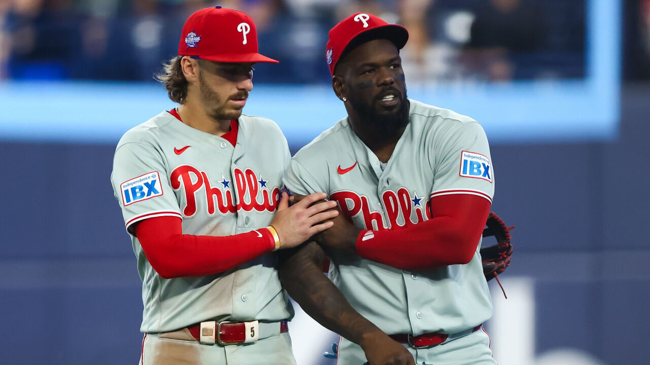 TORONTO, CANADA - JUNE 10: Bryson Stott #5 of the Philadelphia Phillies helps Adolis García #53 after García was injured on the field during seventh inning of their MLB game against the Toronto Blue Jays at Rogers Centre on June 10, 2026 in Toronto, Ontario, Canada.