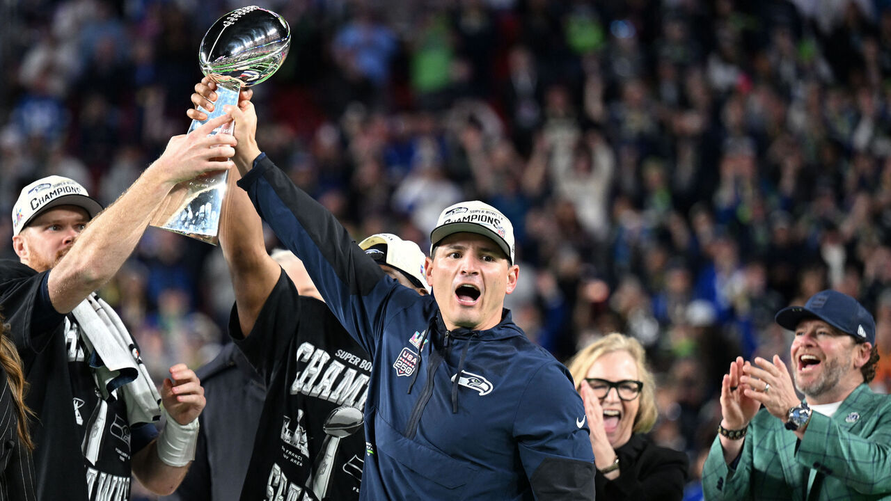 Seattle Seahawks' quarterback #14 Sam Darnold and Seattle Seahawks' head coach Mike Macdonald celebrate with the Vince Lombardi Trophy as Seattle Seahawks' owner Jody Allen and general manager John Schneider applaud after the Seattle Seahawks defeated the New England Patriots during Super Bowl LX at Levi's Stadium in Santa Clara, California on February 8, 2026.